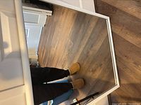 Front view of rectangular mirror showing white frame and reflection