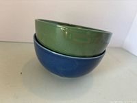 Green bowl stacked on blue bowl showing colors and glaze