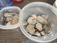 Two plastic containers filled with assorted U.S. coins