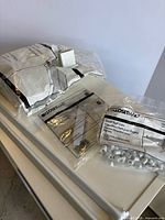 Three sealed ClosetMaid accessory bags on tabletop