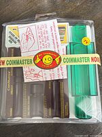 Front view of sealed Coinmaster coin rolling kit showing all components inside clamshell packaging