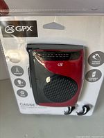 Front of sealed package showing red/black GPX CAS337B cassette player and earbuds