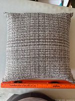 Full view of square pillow with ruler showing approximately 16 in size