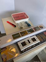 Lot overview showing hanger system package, wall plates, utility knife, picture hanging kit and hardware bag