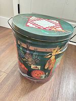 Full view of tin showing side artwork and handles