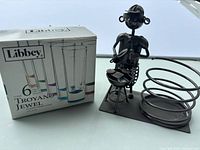 Boxed Libbey Troyano Jewel shot glasses beside metal bottle holder