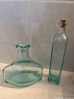 Front view of both glass bottles showing shapes and color