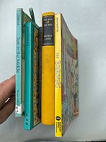Spine view of five books showing titles and formats