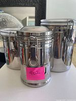 Three stainless clamp-seal canisters, front and side view