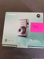 Retail box front showing Canon PowerShot ELPH 300 HS camera image and specifications