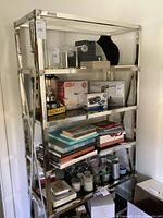 Full view of chrome frame shelf with five black glass shelves