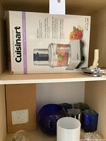 Boxed Cuisinart processor, crystal and glass decor items on shelf