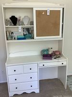 Front view of white desk with hutch, drawers, cork board