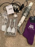 Group shot showing flat iron, toothbrush heads, cables, wall adapter, socks
