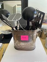 Silver-plated holder filled with assorted kitchen utensils