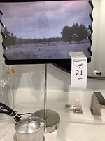 Lamp base, shade, lidded metal container on countertop