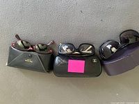 Three pairs of sunglasses with respective cases lined up