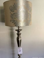 Upper portion of floor lamp showing shade and brushed nickel stem