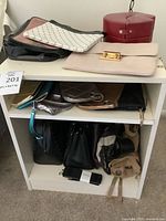 Front view of white two-shelf side table with handbags shown for scale