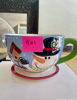 Large Christmas-themed ceramic cup with snowman motif on matching saucer