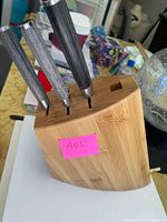 Front and side view of bamboo wooden knife block with three knives inserted