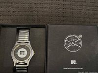 Metal MTV watch with silver expandable band inside original black box.