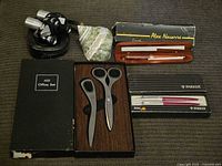 Complete group showing all items, including the Parker pen set, Alex office set, miniature binoculars, and shell.