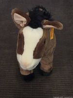 Front view of the brown and white Steiff horse plush toy showing its soft fur, black mane, and facial features.