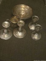 Group shot of all six silver items arranged on fabric background