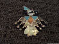 Close-up front view of the vintage Thunderbird brooch showing turquoise, coral, onyx, and shell inlay details.