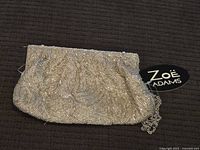 Front view of Zoe Adams silver beaded purse showing intricate beading and brand tag.