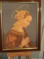 Full view of framed textile art on easel