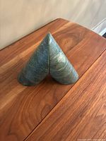 Front view of both green marble conical bookends standing together