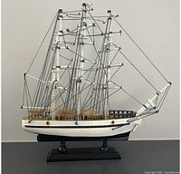 Port-side view of full three-masted model ship on stand