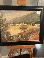 Full view of framed watercolor painting on easel