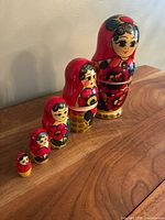 Five nesting dolls lined up by size on wooden surface