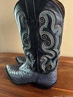 Side view of both boots showing shaft stitching and ostrich leather feet