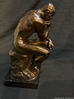 Full view of sculpture showing seated figure and base