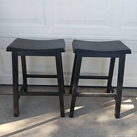 Both black wooden stools side by side