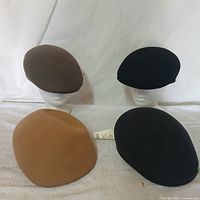 Four cabbie hats laid out to show colors and shapes