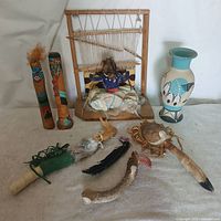 Group shot of all Indigenous American items including carvings, loom diorama, pottery vase and ceremonial pieces