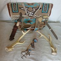 All items laid out: tapestry bag, two antlers, tomahawk, stick, ornament
