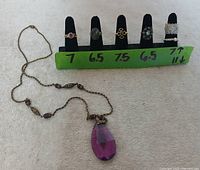 Overview of five rings on size display and necklace laid out