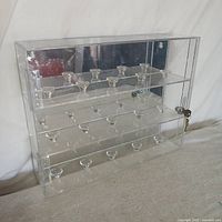 Front view of clear acrylic baseball display case showing four shelves with molded ball holders