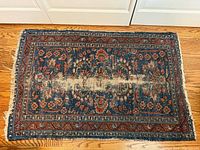 Full view of rug showing pattern, colors and wear