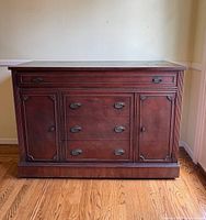 Front view of dark wooden vintage buffet dresser with drawers and cabinets showing rope-style carved trim and metal handles
