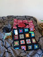 Overview of both blankets, handbags and scarves on bed