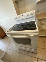 Full view of white Kenmore electric range showing oven door and cooktop