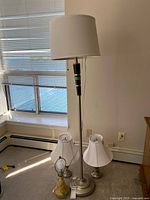 Group shot of all four lamps: floor lamp, two small metal lamps, ceramic lamp