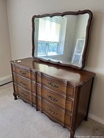 Front view of Malcolm French Provincial dresser with attached mirror showing nine drawers and ornate pulls